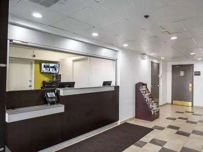an office lobby with a reception desk and a mirror at Studio 6-Miamisburg, OH - Dayton in Miamisburg