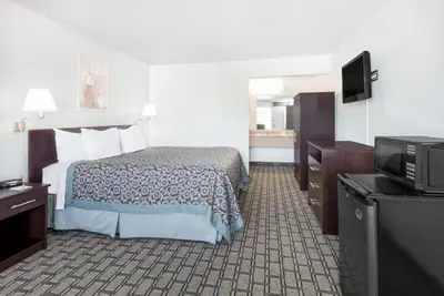 a hotel room with a bed and a flat screen tv at Days Inn by Wyndham St Clairsville in Saint Clairsville