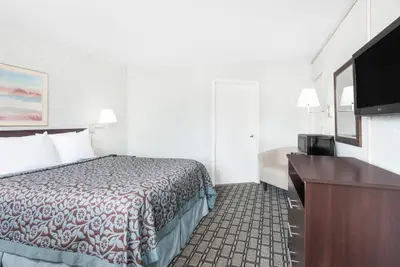 a hotel room with a bed and a flat screen tv at Days Inn by Wyndham St Clairsville in Saint Clairsville
