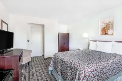 a hotel room with a bed and a flat screen tv at Days Inn by Wyndham St Clairsville in Saint Clairsville