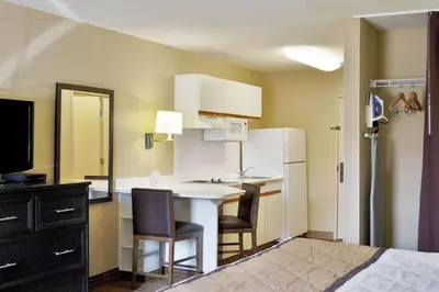 a small kitchen with a table and a refrigerator at Candlewood Suites Beachwood Cleveland by IHG in Beachwood