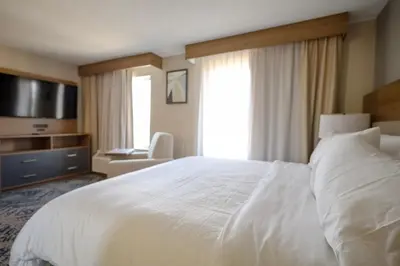 a hotel room with a white bed and a television at Candlewood Suites Beachwood Cleveland by IHG in Beachwood