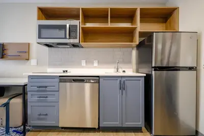 a kitchen with a stainless steel refrigerator and a microwave at Candlewood Suites Beachwood Cleveland by IHG in Beachwood