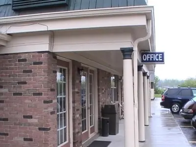 a brick building with a sign that reads office at Hometown Inn Galion in Galion