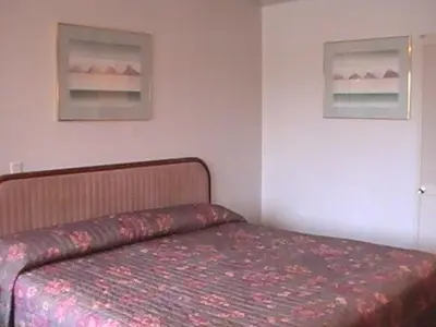 a bedroom with a bed and two pictures on the wall at Hometown Inn Galion in Galion