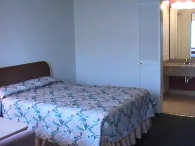 a small bedroom with a bed and a sink at Hometown Inn Galion in Galion