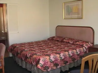 a bed in a room with a bedspread on it at Hometown Inn Galion in Galion