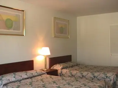 a hotel room with two beds and a lamp at Hometown Inn Galion in Galion