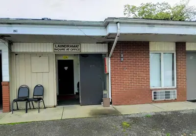 a building with two chairs sitting outside of it at Davis Motel in North Lima
