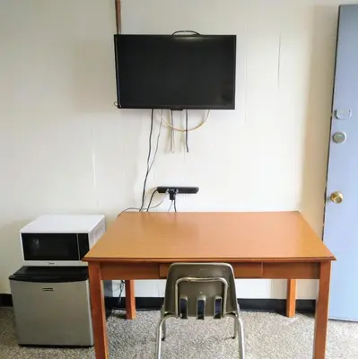 a wooden table with a chair and a television on a wall at Davis Motel in North Lima
