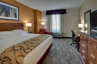 a hotel room with a bed and a desk and a television at Drury Inn & Suites Findlay in Findlay