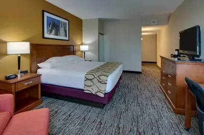 a hotel room with a bed and a flat screen tv at Drury Inn & Suites Findlay in Findlay