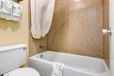 a bathroom with a white tub and a toilet at Rodeway Inn Jeffersonville - Washington Court House in Jeffersonville