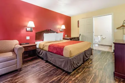 a hotel room with a bed and a chair at Rodeway Inn Jeffersonville - Washington Court House in Jeffersonville
