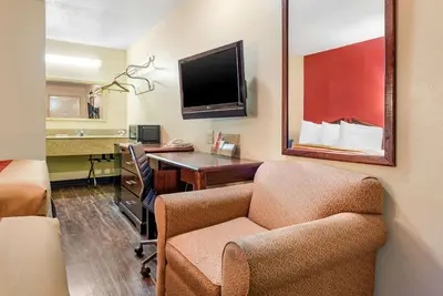 a room with a desk and a chair and a mirror at Rodeway Inn Jeffersonville - Washington Court House in Jeffersonville