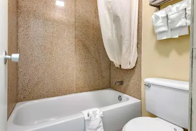 a bathroom with a white tub and a toilet at Rodeway Inn Jeffersonville - Washington Court House in Jeffersonville