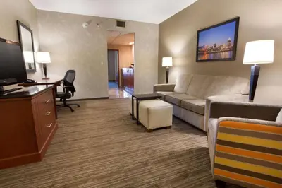 a living room with a couch and a desk at Drury Inn & Suites Cincinnati Sharonville in Sharonville