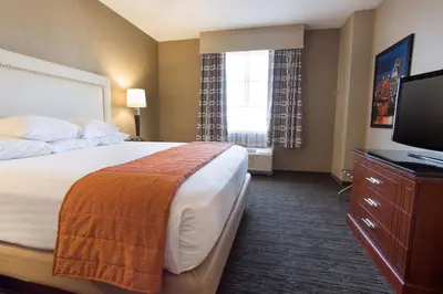 a hotel room with a bed and a flat screen tv at Drury Inn & Suites Cincinnati Sharonville in Sharonville
