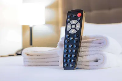 a remote control sitting on top of a pile of towels at Drury Inn & Suites Cincinnati Sharonville in Sharonville