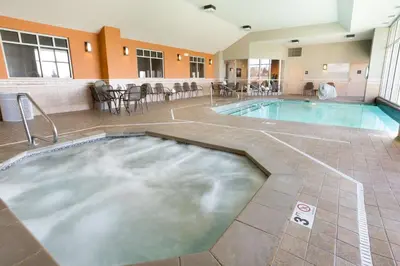 a large pool in a hotel with chairs and tables at Drury Inn & Suites Cincinnati Sharonville in Sharonville