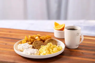 a plate of breakfast food and a cup of coffee at Drury Inn & Suites Cincinnati Sharonville in Sharonville