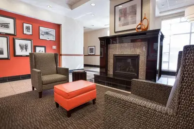 a waiting room with chairs and a fireplace at Drury Inn & Suites Columbus Grove City in Grove City