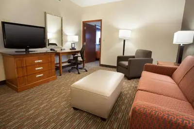 a hotel room with a couch and a tv and a desk at Drury Inn & Suites Columbus Grove City in Grove City