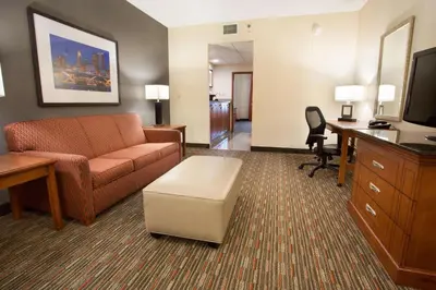 a living room with a couch and a desk at Drury Inn & Suites Columbus Grove City in Grove City