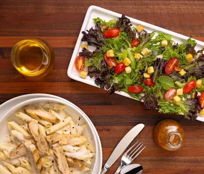 a table with a salad and a bowl of french fries at Drury Inn & Suites Columbus Grove City in Grove City