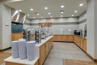 a large kitchen with wooden cabinets and white plates at Drury Inn & Suites Dayton North in Dayton