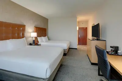 a hotel room with two beds and a desk at Drury Inn & Suites Dayton North in Dayton