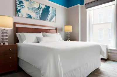 a bedroom with a large bed with white sheets at The Westin Great Southern Columbus in Columbus