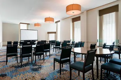 a conference room with tables and chairs and a screen at The Westin Great Southern Columbus in Columbus
