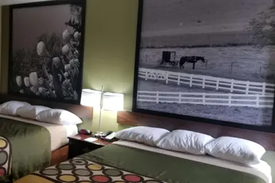 a hotel room with two beds and a picture of a horse at Super 8 by Wyndham Bellefontaine in Bellefontaine