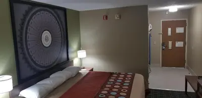 a room with a bed with a large picture on the wall at Super 8 by Wyndham Bellefontaine in Bellefontaine
