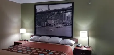 a bedroom with a bed with a picture on the wall at Super 8 by Wyndham Bellefontaine in Bellefontaine