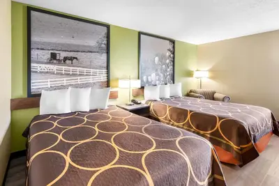 a hotel room with two beds and a painting on the wall at Super 8 by Wyndham Bellefontaine in Bellefontaine