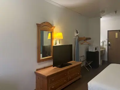 a bedroom with a television on a dresser with a mirror at Motel 6 Portland, IN in Portland