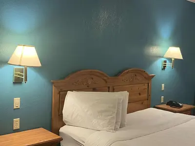 a bedroom with a bed and a blue wall at Motel 6 Portland, IN in Portland