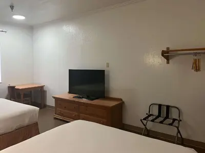 a bedroom with a tv on a dresser with a bed at Motel 6 Portland, IN in Portland