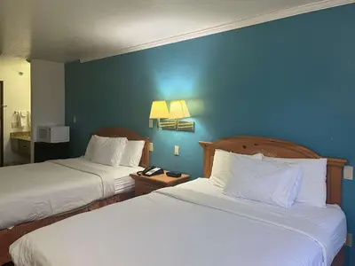 a hotel room with two beds and a blue wall at Motel 6 Portland, IN in Portland