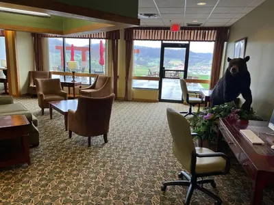 a waiting room with a bear statue on the wall at Days Inn & Suites by Wyndham Sutton Flatwoods in Sutton