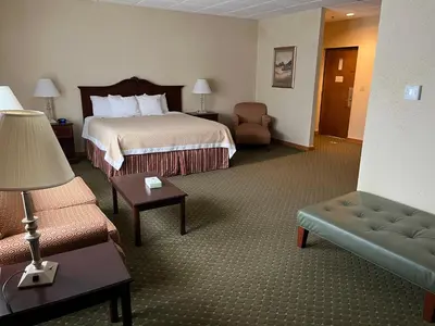 a hotel room with a bed and a couch at Days Inn & Suites by Wyndham Sutton Flatwoods in Sutton