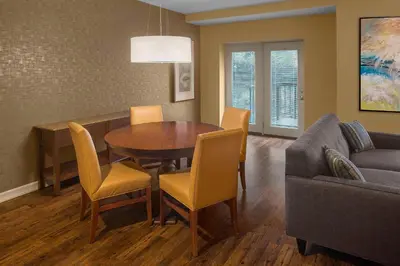 a living room with a table and chairs and a couch at Sheraton Suites Akron Cuyahoga Falls in Cuyahoga Falls