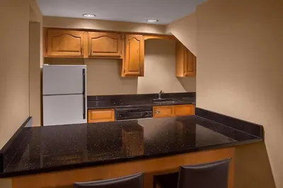 a kitchen with a black counter top and wooden cabinets at Sheraton Suites Akron Cuyahoga Falls in Cuyahoga Falls