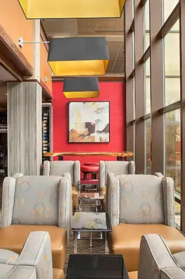 a waiting room with chairs and a red wall at Sheraton Suites Akron Cuyahoga Falls in Cuyahoga Falls