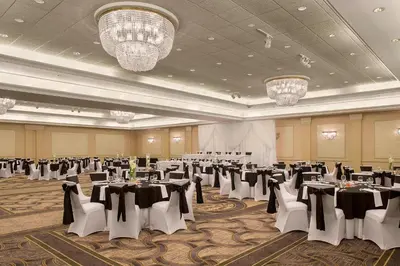 a banquet hall with tables and chairs and chandeliers at Sheraton Suites Akron Cuyahoga Falls in Cuyahoga Falls
