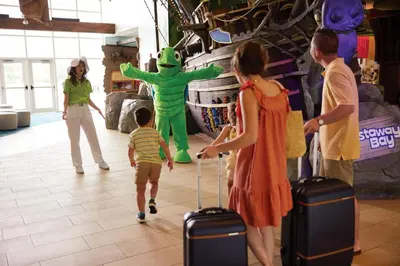 a group of people standing in a store with a child pulling a suitcase at Castaway Bay by Cedar Point Resorts in Sandusky