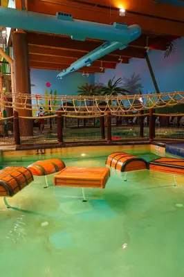a swimming pool with orange and brown benches in the water at Castaway Bay by Cedar Point Resorts in Sandusky