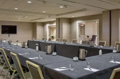 a conference room with tables and chairs and a screen at Hyatt Regency Cleveland at The Arcade in Cleveland